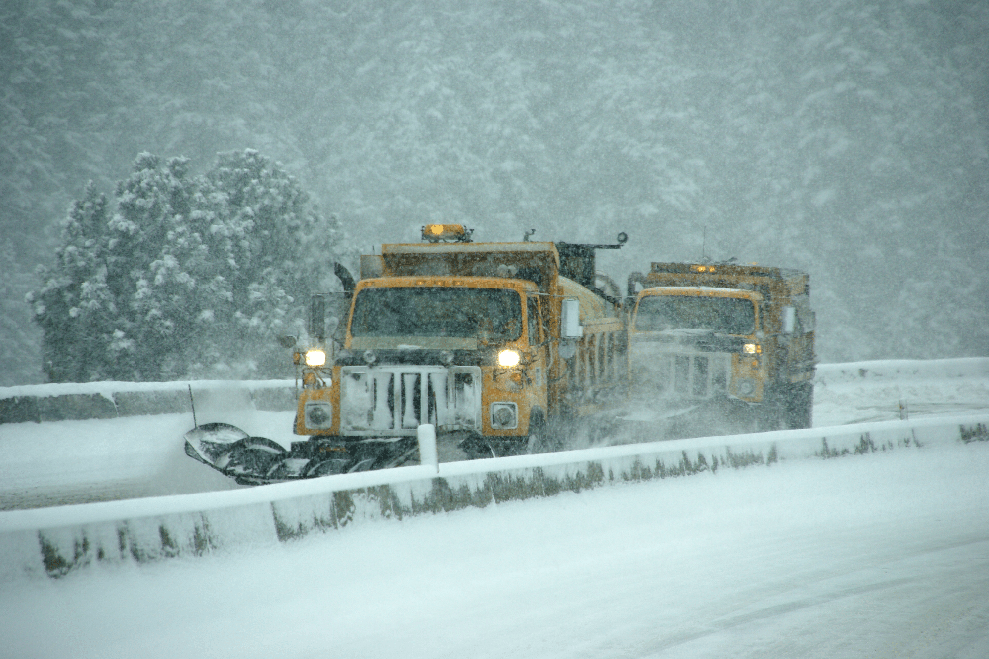 Snow plows moving snow off of highway